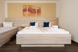 2 Betten in einem Hotelzimmer mit weißen und blauen Kissen in der Unterkunft Hotel Apollon Rust in Rust