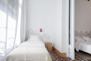 1 Schlafzimmer mit 2 Betten und einem Spiegel in der Unterkunft La Casa de Antonio Boutique Rooms in Barcelona