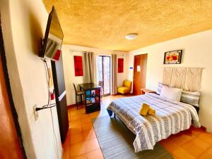 - une chambre avec un lit et une télévision dans l'établissement Casa Rofo, à Guanajuato