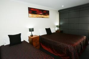 ein Schlafzimmer mit 2 Betten und einem Wandgemälde in der Unterkunft Amber Lodge Motel in Gladstone