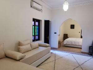 uma sala de estar com um sofá e uma cama em Riad Bijoux em Marraquexe