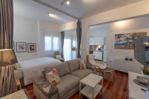 uma sala de estar com um sofá e uma cama em Λάρισα διαμέρισμα με θέα πλατεία στο κέντρο της πόλης em Lárissa