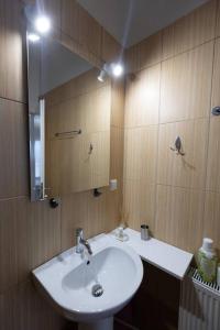 uma casa de banho com um lavatório branco e um espelho. em Λάρισα διαμέρισμα με θέα πλατεία στο κέντρο της πόλης em Lárissa