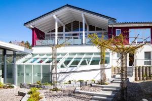 a large white building with glass windows at Bio- und Wellnesshotel Alpenblick in Höchenschwand