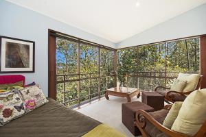 a bedroom with a bed and a large window at Lyola Pavilions in the Forest in Maleny
