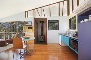 a kitchen and dining room with a table and a stove at Lyola Pavilions in the Forest in Maleny