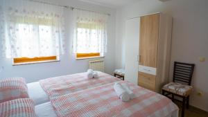 ein Schlafzimmer mit einem Bett mit zwei Handtüchern darauf in der Unterkunft Apartma Tri oljke in Dobrovo