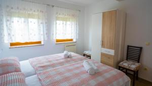 1 dormitorio con 1 cama con 2 toallas en Apartma Tri oljke, en Dobrovo