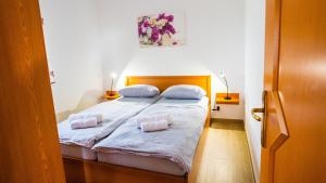a bedroom with a bed with two pillows on it at Apartma Tri oljke in Dobrovo