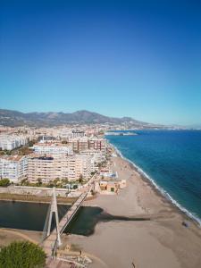 a view of a beach with buildings and the ocean at Apartamento moderno y acogedor cerca del mar in Fuengirola