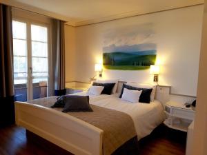 a bedroom with a large bed with a painting on the wall at Bio- und Wellnesshotel Alpenblick in Höchenschwand