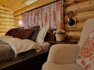 um quarto com um sofá e uma cadeira num chalé de madeira em Troya Chalets em Baba Stana