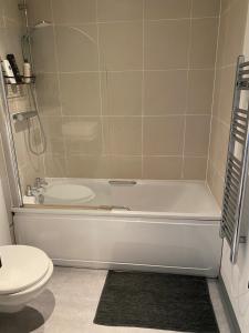a bathroom with a white tub and a toilet at Stunning apartment in the heart of Leeds in Leeds