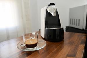 a glass of coffee on a table next to a toaster at El Hostal de Violeta in Tomelloso