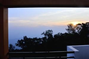 a view of the sunset from the balcony of a house at TGT Holidays Yercaud in Yercaud