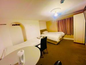 a hotel room with two beds and a table and a sink at White House Lodge in Cambridge