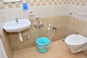 a bathroom with a sink and a toilet and a bucket at TGT Holidays Yercaud in Yercaud