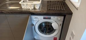 een wasmachine onder een aanrecht met een wastafel bij Stunning 3 bed House sleeps 5-6, WiFi, OFF Street Parking in Nottingham close to M1 in Nottingham