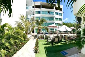a hotel with chairs and tables in front of a building at Gran Palma in Acapulco