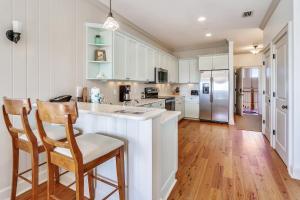 una cocina con armarios blancos, encimera y sillas en Standard 2 Bedroom C, en Holmes Beach