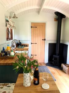 a kitchen with a table with a wine glass and a stove at Lilliput - Delightful 1-bedroom shepherd's hut in Holsworthy