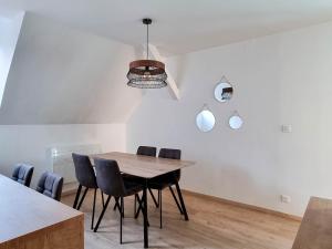 uma sala de jantar com uma mesa de madeira e cadeiras em Travel Homes - NewGate 3, elegant, heart of Colmar em Colmar