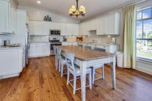a kitchen with a wooden table and white cabinets at Townhouse 3 Bedroom B in Holmes Beach