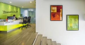 an office with a desk and two pictures on the wall at Marvin Suites Hotel in Bangkok