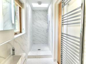 a white bathroom with a shower and a sink at Baltinna East - by Where Stags Roar in Newtonmore