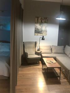 een woonkamer met een bank en een tafel bij Piekarnia Apartamenty Manufaktura parking dostep na kod 1-3 pokoje prywatna kamienica in Łódź