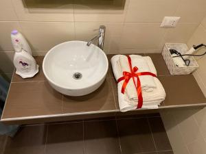 a bathroom counter with a sink and towels on it at Guest house Novecento in Palo del Colle