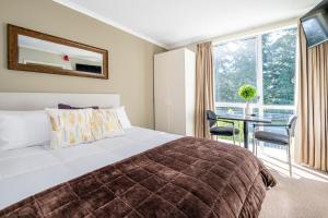 a bedroom with a bed and a table and a window at Sunny Apartment Methven in Methven