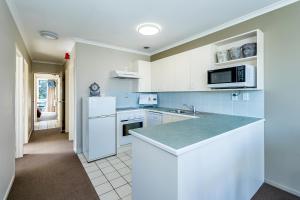 a kitchen with white cabinets and a counter top at Sunny Apartment Methven in Methven