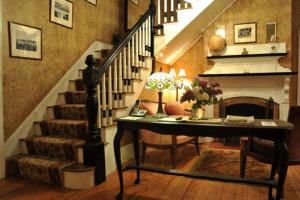 a room with a staircase with a desk and a fireplace at Central House Inn in Bar Harbor