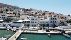 a group of white buildings with boats in a harbor at Batsi Bay Premium in Batsi