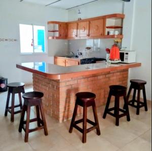 a kitchen with a counter and some bar stools at Hospedaje Mérida in San Rafael