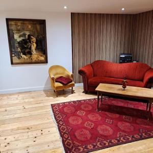 - un salon avec un canapé rouge et une table dans l'établissement Résidence La Mamone, à Ornans