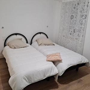 dwa łóżka siedzące obok siebie w pokoju w obiekcie Résidence La Mamone w mieście Ornans