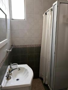 y baño con lavabo y ducha. en Departamento Mitre- Pleno corazón de la Ciudad. en Mendoza