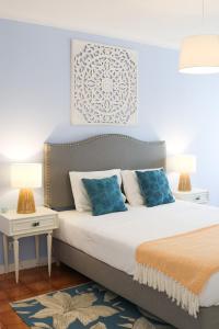 a bedroom with a large bed with blue pillows at Amélia - Always Algarve in Armação de Pêra
