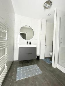 La salle de bains est pourvue d'un lavabo, d'un miroir et de toilettes. dans l'établissement Wohnung in Kassel mit Ladesäulen, à Cassel