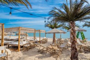 a beach wedding with chairs and umbrellas on the sand at Villa Orange in Sozopol