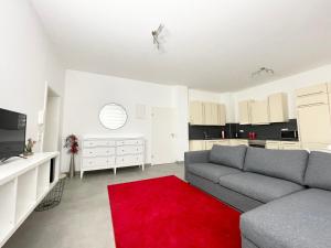 - un salon avec un canapé et un tapis rouge dans l'établissement Wohnung in Kassel mit Ladesäulen, à Cassel