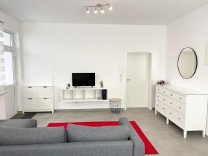 sala de estar blanca con sofá y TV en Wohnung in Kassel mit Ladesäulen, en Kassel
