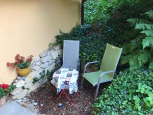 2 chaises et une table assise à côté d'un mur dans l'établissement Happy, à Givisiez