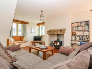 a living room with a couch and a fireplace at Woodfield Coach House in Merrymeet