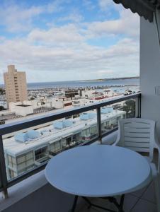 uma mesa branca e cadeiras numa varanda com vista para o oceano em Peninsula em Punta del Este