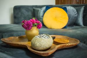 ein Holztablett mit einer Vase mit Blumen auf dem Tisch in der Unterkunft Masakali Retreat in Ubud