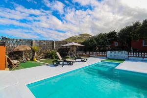 una piscina con mesa y sillas en un patio en Cute Villa with Views and Pool, en Santa María de Guía de Gran Canaria