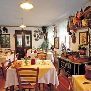 um restaurante com mesas e cadeiras e um fogão em Albergo Piani di Luzza em Forni Avoltri